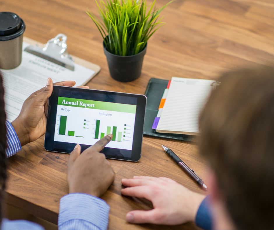 People using an ipad to discuss an annual report.