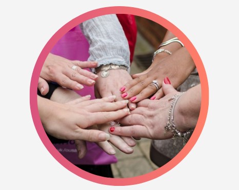 A group of people with their hands joined together in a circle.