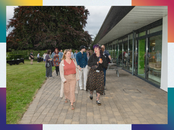 A group of happy people walking together outside, framed with colourful corners.
