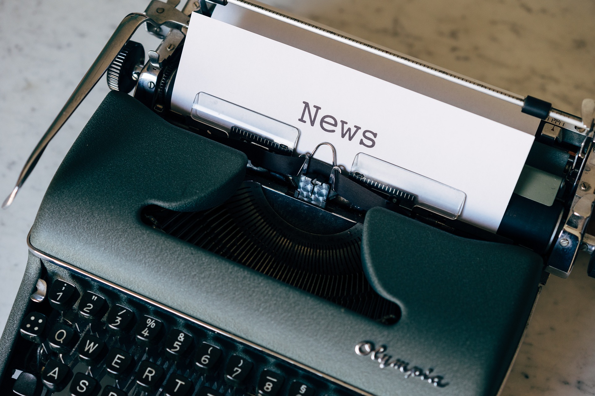 A typewriter with a piece of paper saying 'News' inside it.