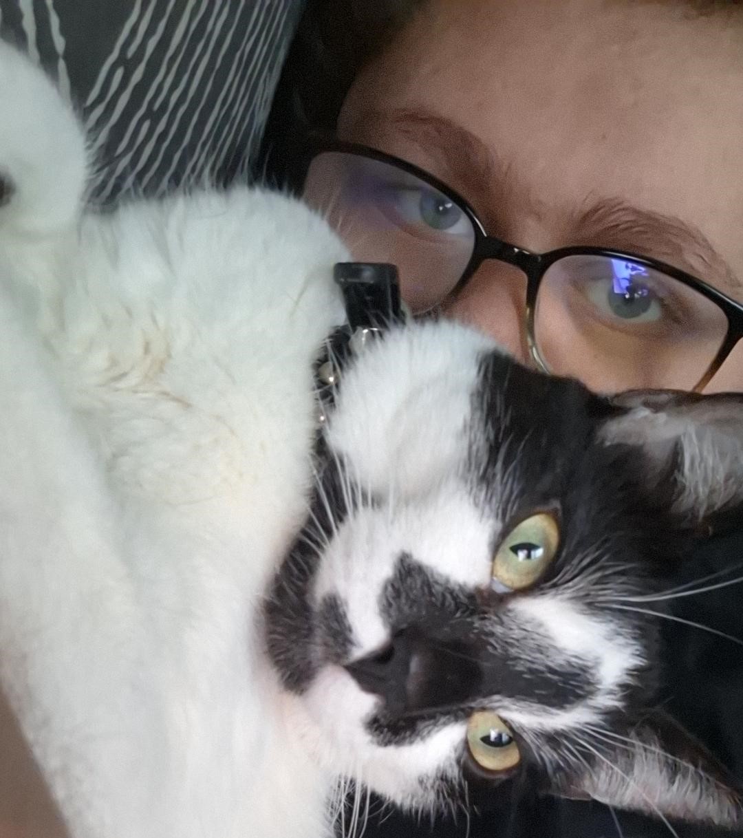 KJ holding her black and white cat up to the camera.