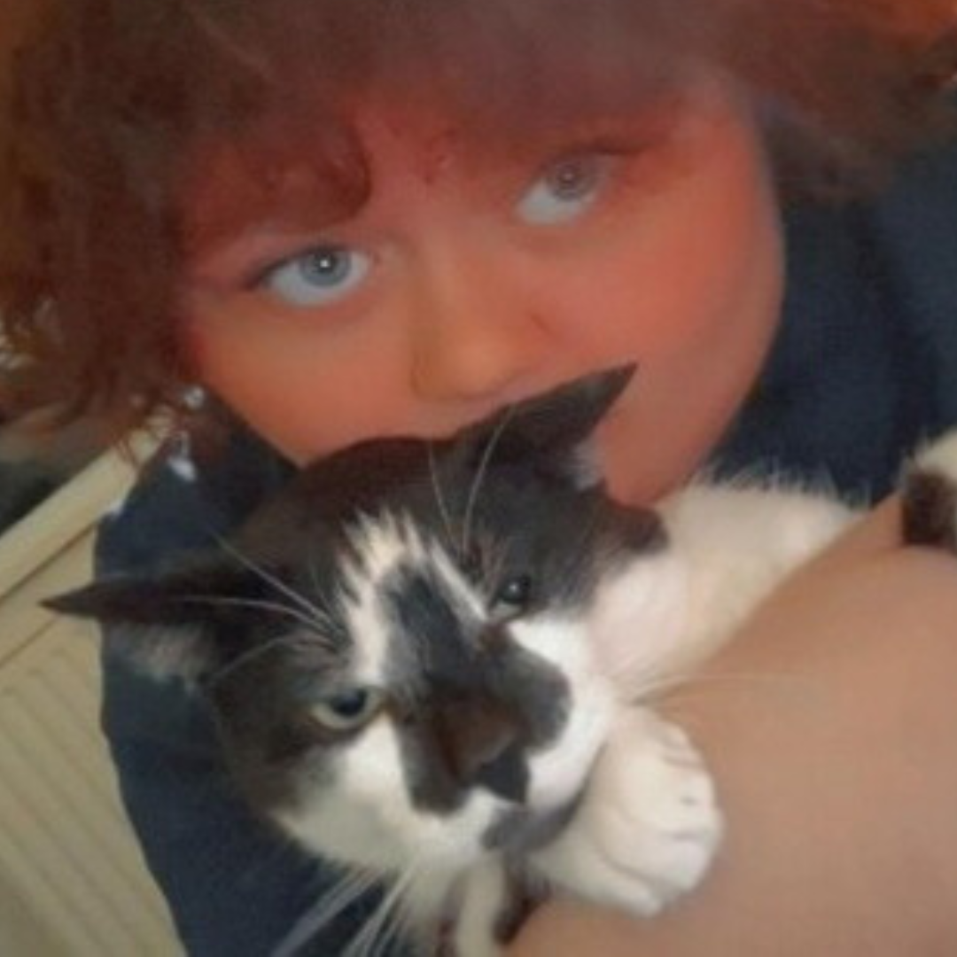 KJ looking at the camera, holding up his pet cat.