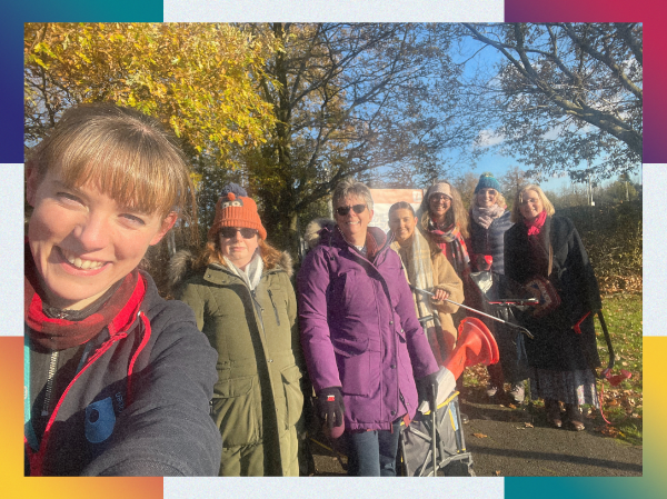 A group of people smiling together outside, framed with colourful corners.