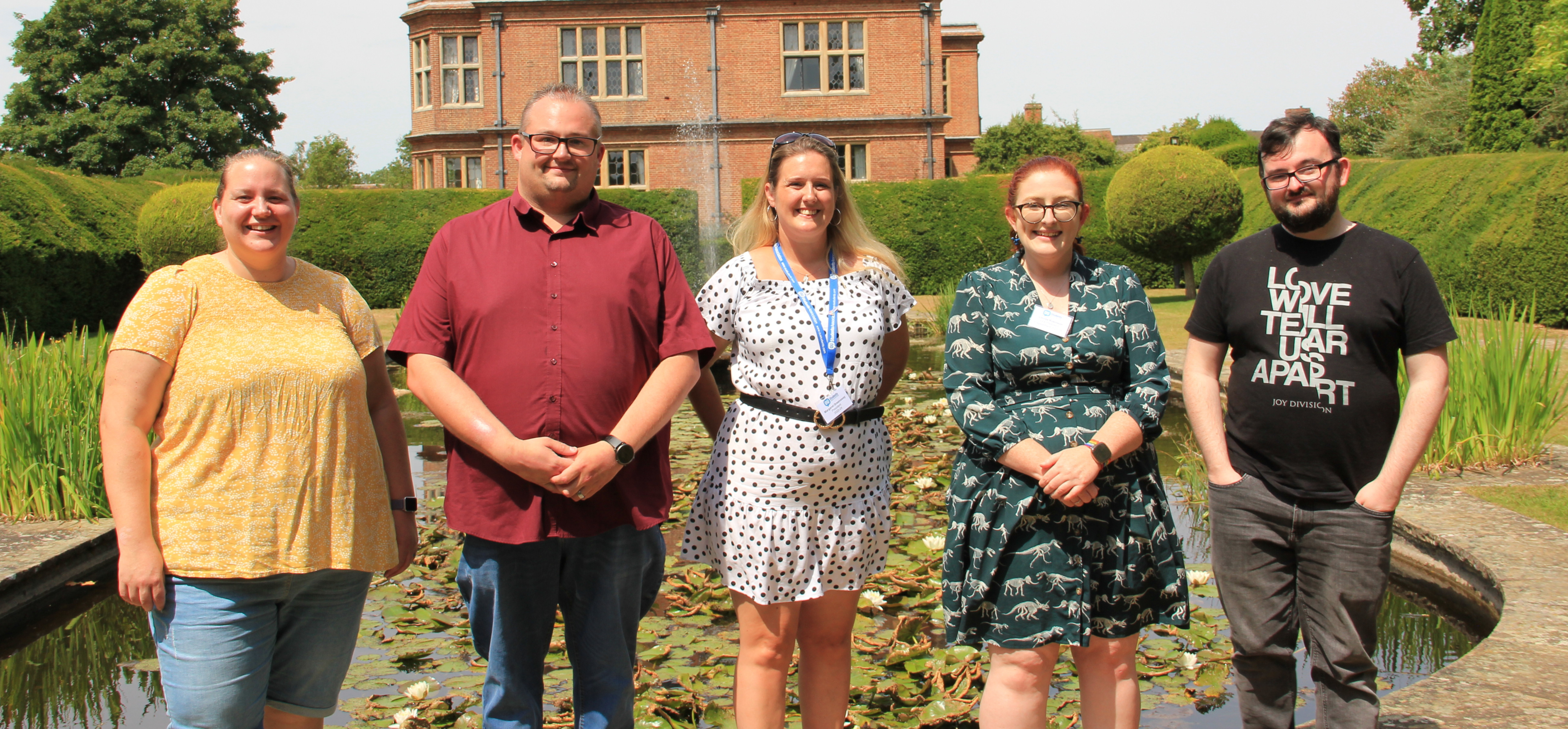 Four members of the Student Leadership Team stood in front of a pond at Horwood House Hotel. 