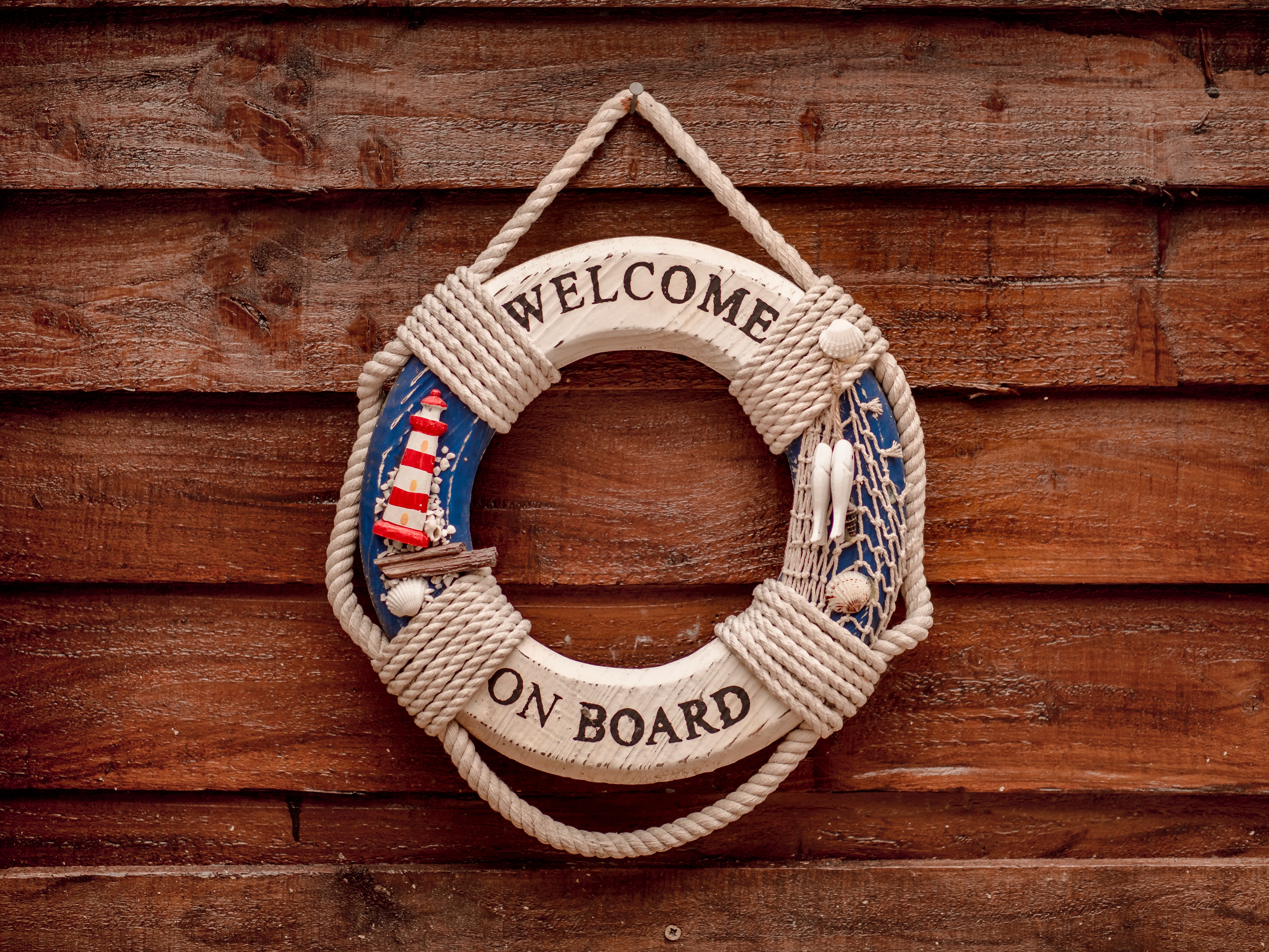 Welcome on board dingy hung on a wooden wall