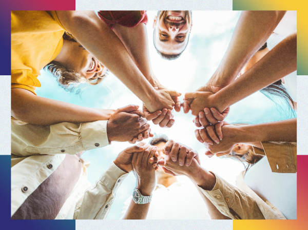 A group of people with their hands together in the middle of a circle.