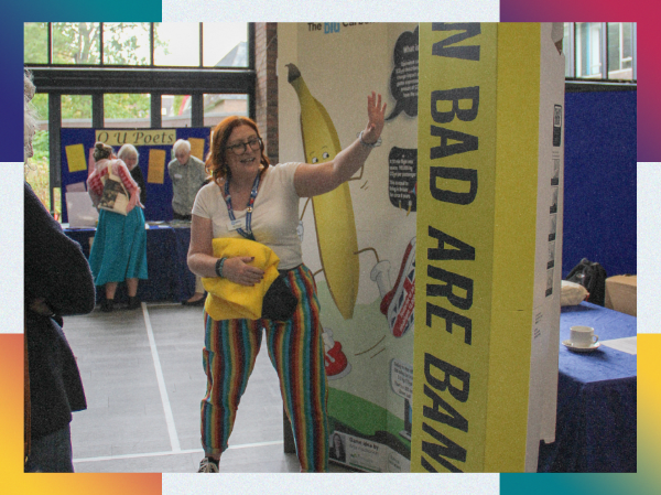 A person speaking about their stall at an in person event, framed with colourful corners.